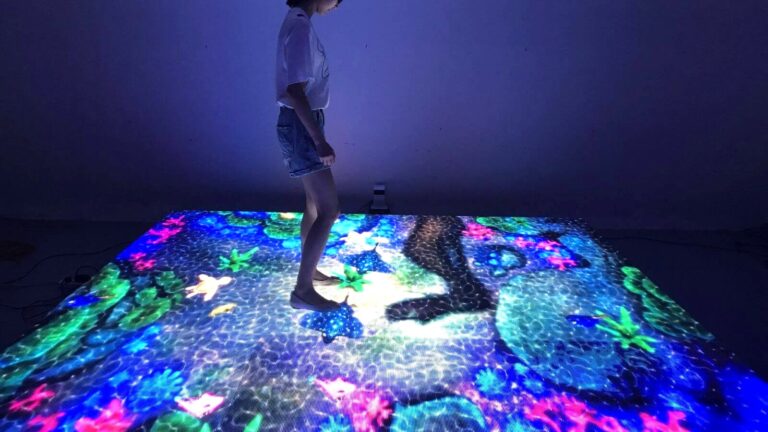Visitor standing on an interactive LED floor showing an underwater scene